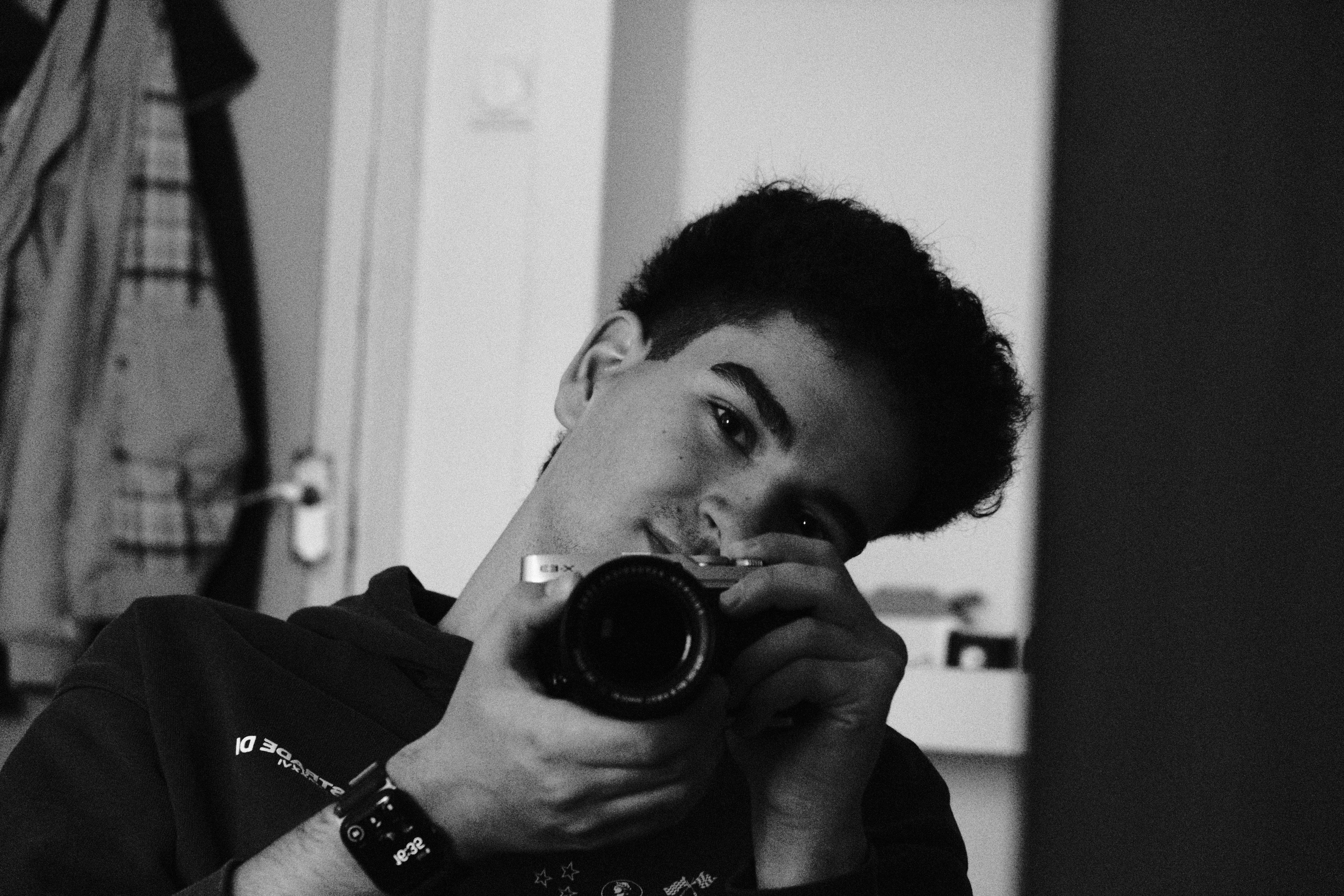 Hunor holding a camera in a black-and-white self-portrait.